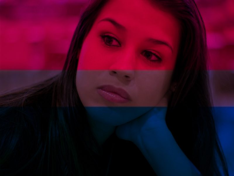 Woman's face looking thoughtful with bi flag colors imposed on top