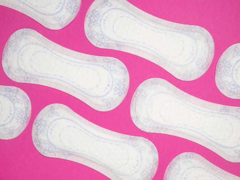 Menstrual health products and supplies (pads, tampons, menstrual cups or reusable cups) on a colorful background.